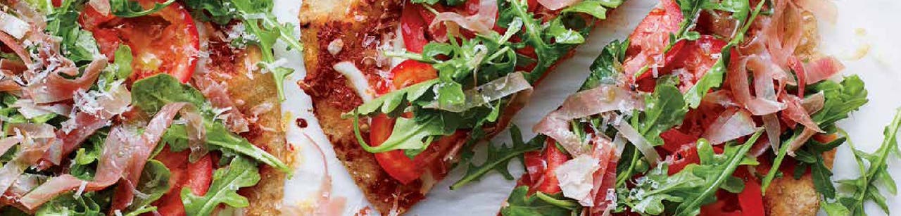 Pizza sur pain plat au prosciutto et à la salade