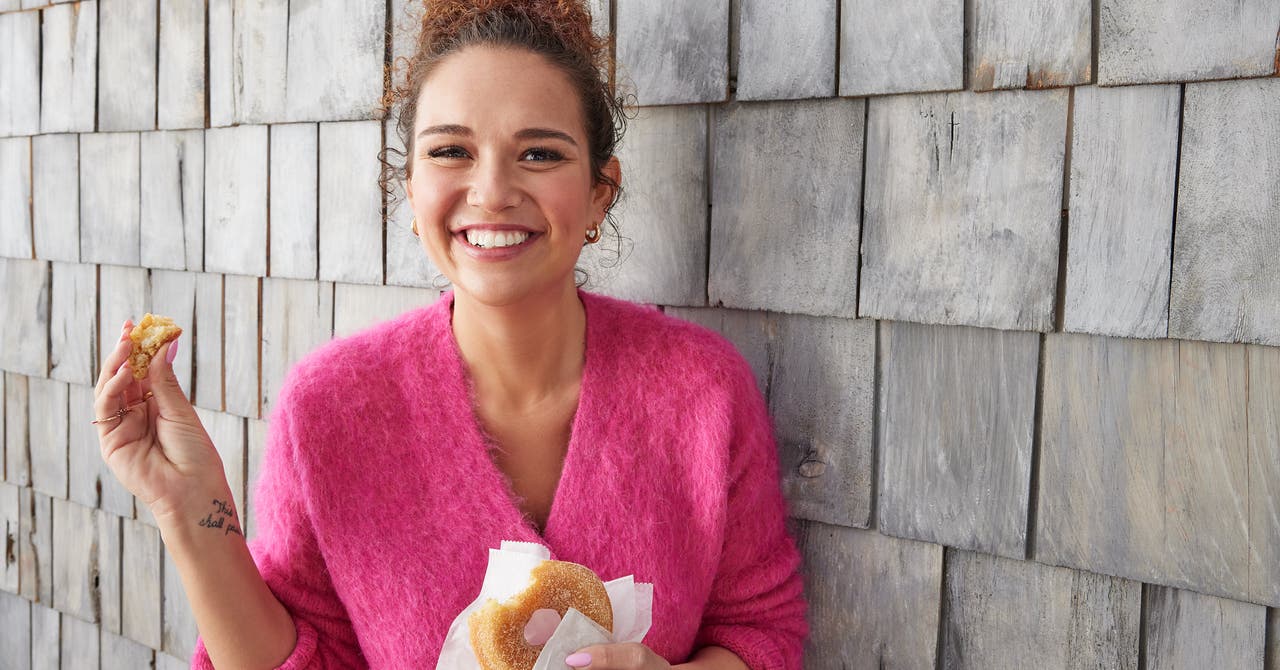 Femme souriante, qui mange un donut