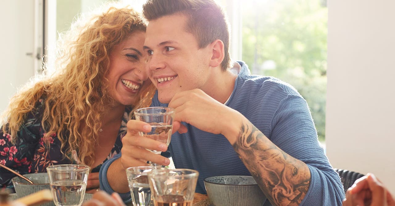 Ein Paar sitzt am Esstisch, der Mann geniesst ein Glas Wein