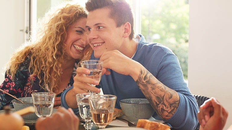 Ein Paar sitzt am Esstisch, der Mann geniesst ein Glas Wein