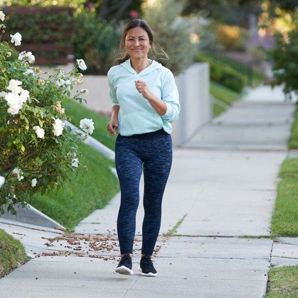 Frau mit asiatischer Herkunft beim Walking im Freien