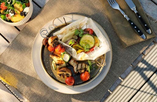 Teller mit Gemüsepäckchen und gegrillten Gemüsespießen