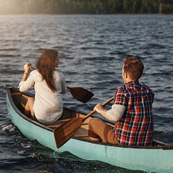 Mann und Frau fahren Kanu auf einem See