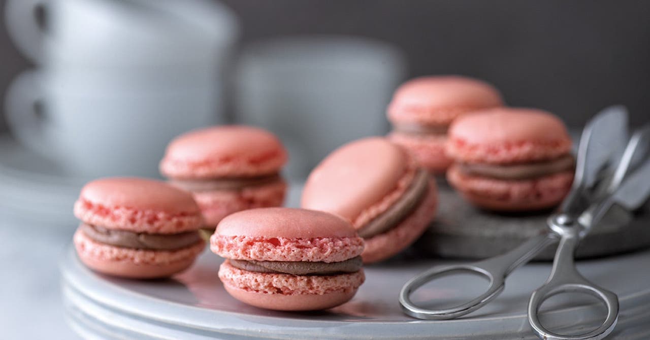 Auf einem Teller liegen rosa Macarons gefüllt mit einer Schokocreme