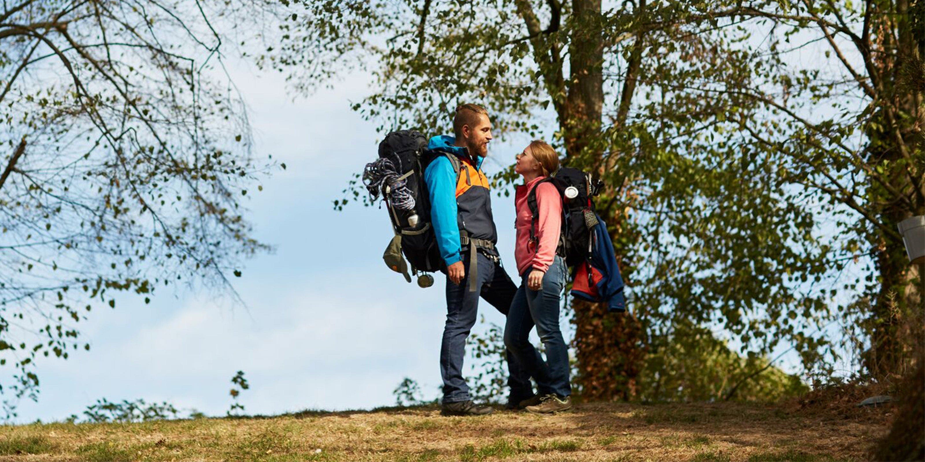 Ein Paar in Wanderkleidung und -ausrüstung