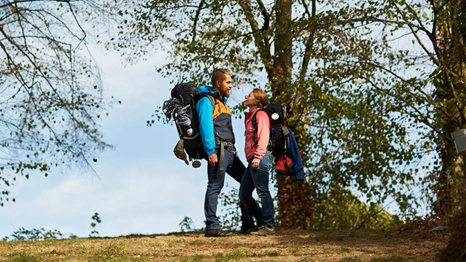 Ein Paar in Wanderkleidung und -ausrüstung