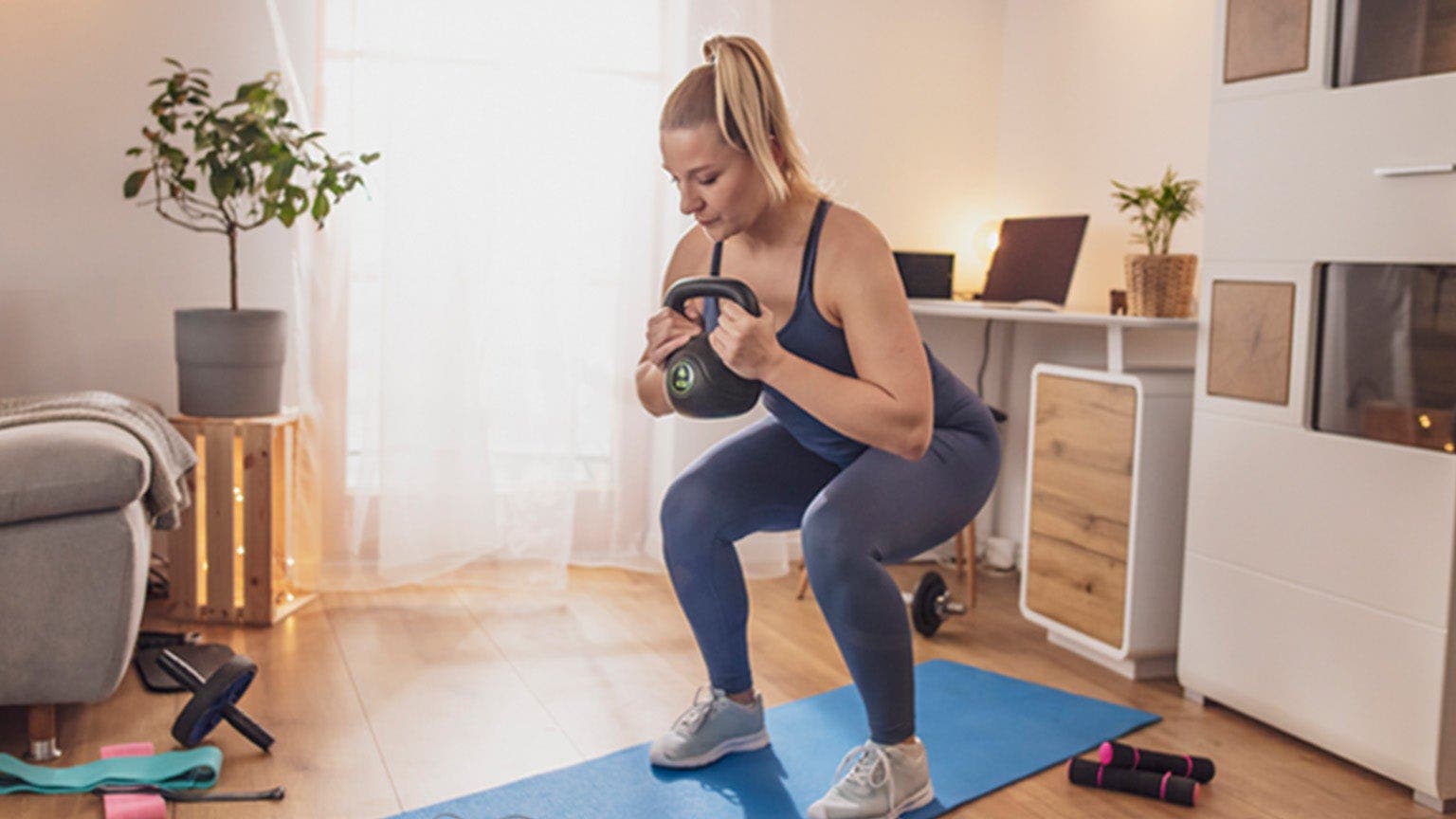 Jeune femme entraînement à la maison avec un poids