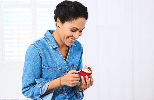 Cecilia, membre de WW, en combinaison en jean, un muffin à la main