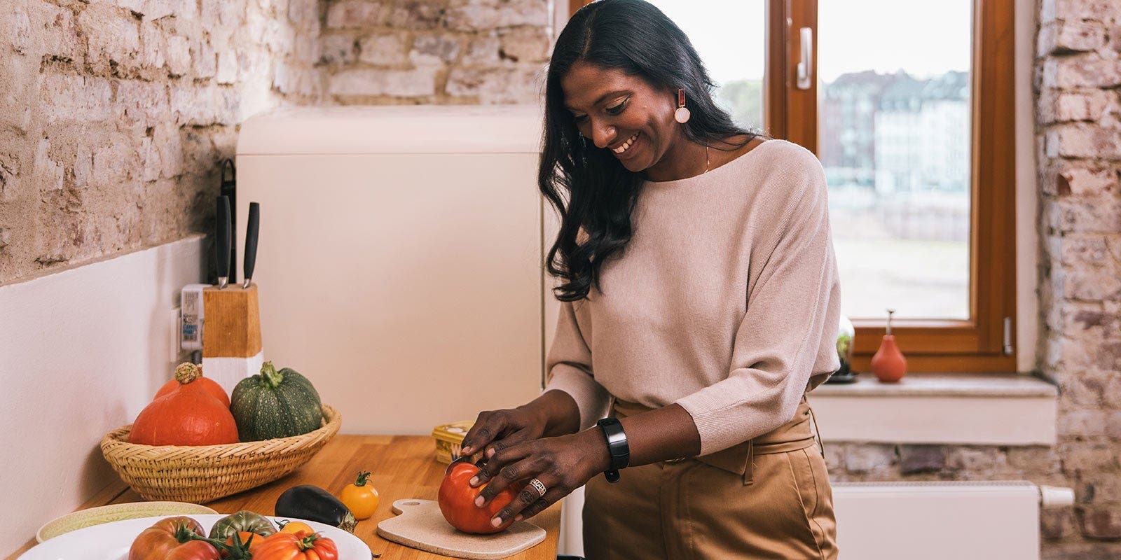 Femme dans la cuisine en train de couper des légumes