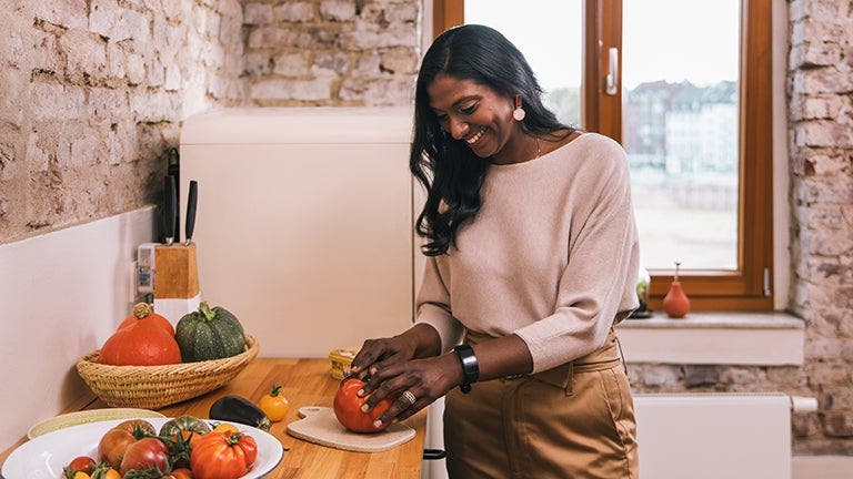 Femme dans la cuisine en train de couper des légumes