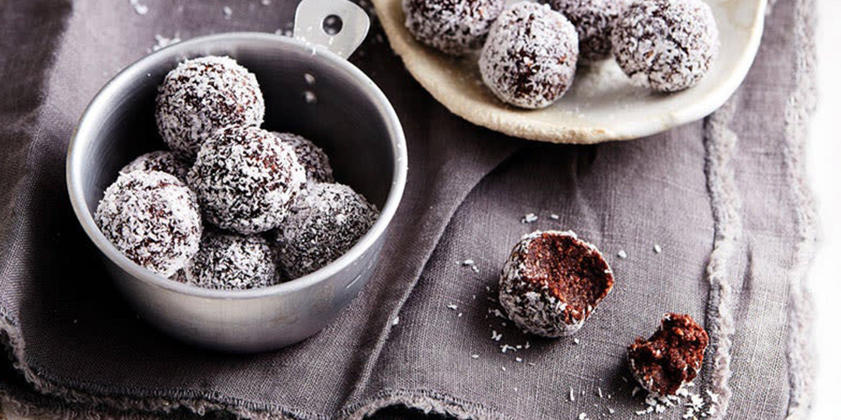 Energyballs mit Kokosraspeln, in zwei Schalen angerichtet.