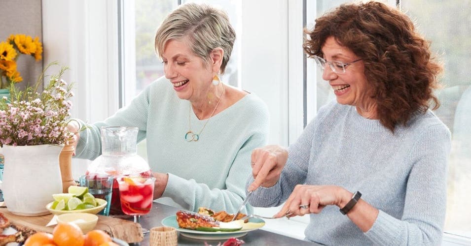 2 Frauen in ihrern Fünfzigern beim Essen am Tisch