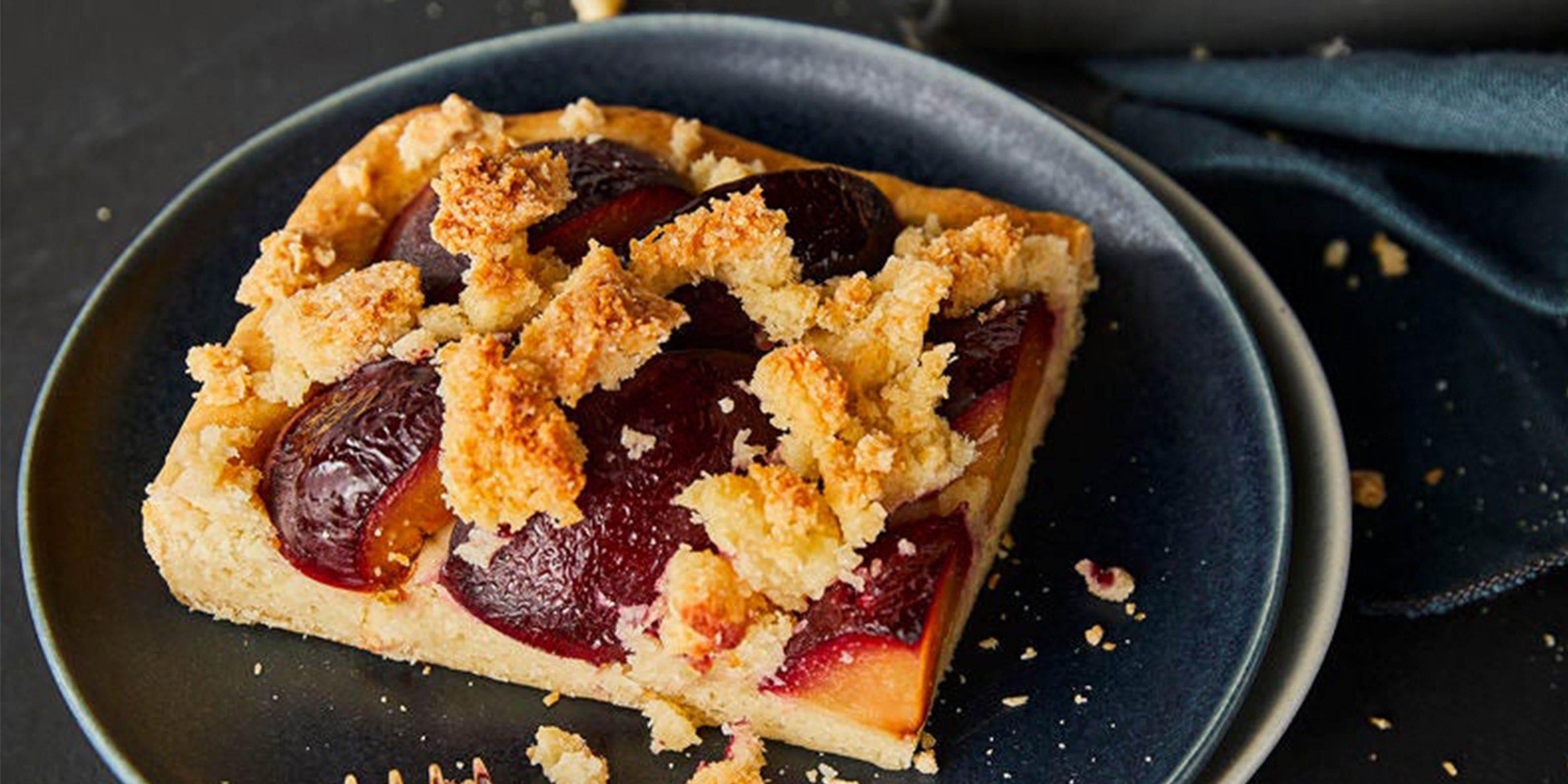 Ein Stück Zwetschgenkuchen mit Streuseln auf einem Teller