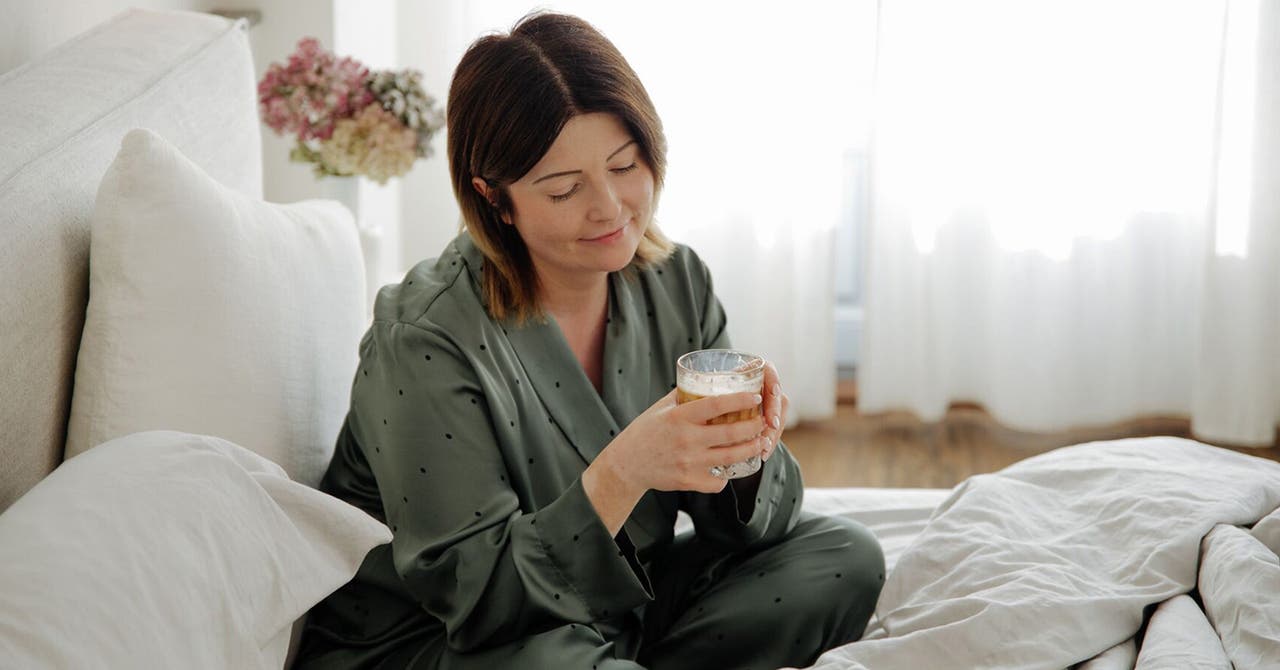 Dominika, membre WW, est assis dans son lit avec une tasse de café.