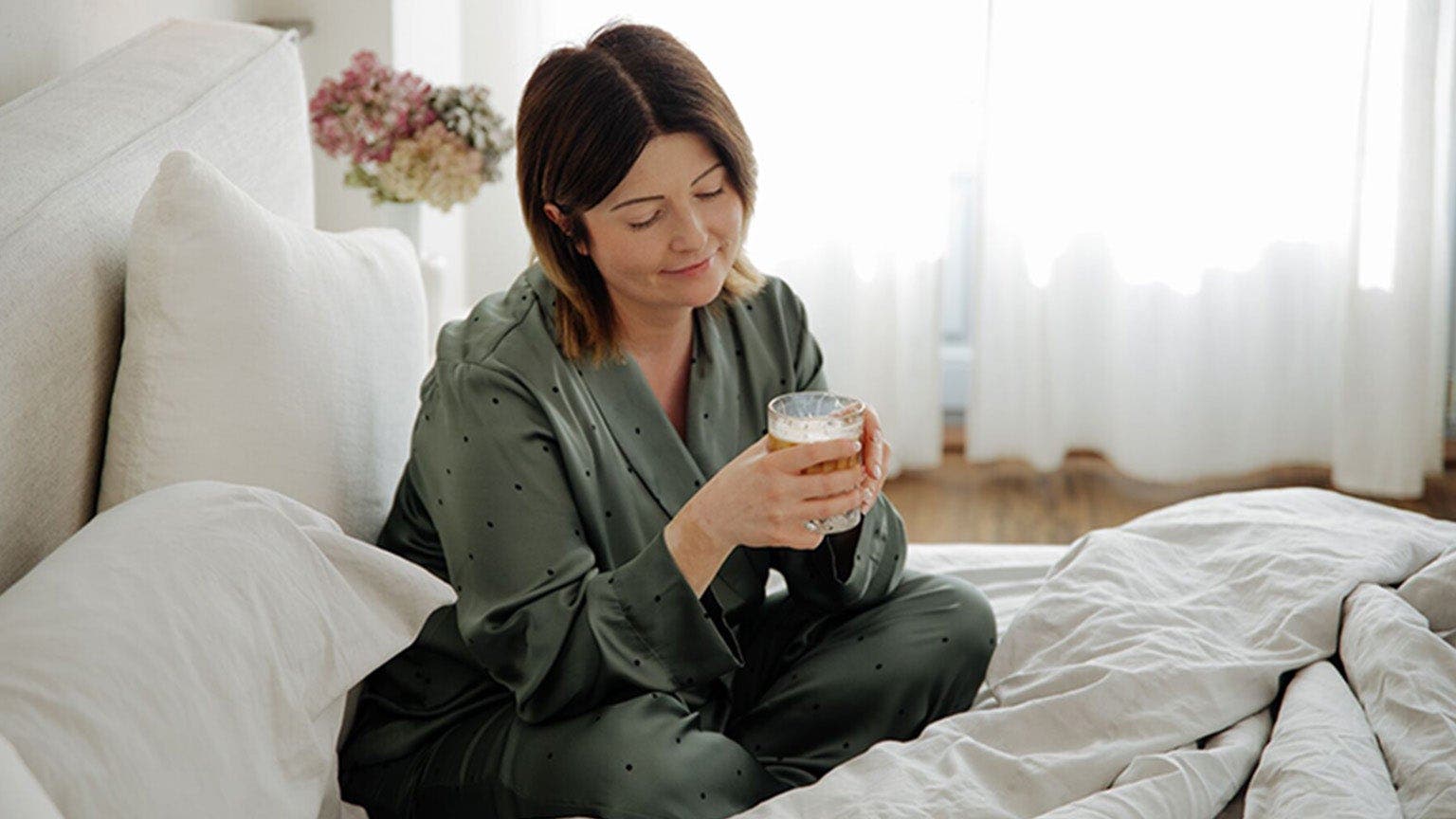 Dominika, membre WW, est assis dans son lit avec une tasse de café.