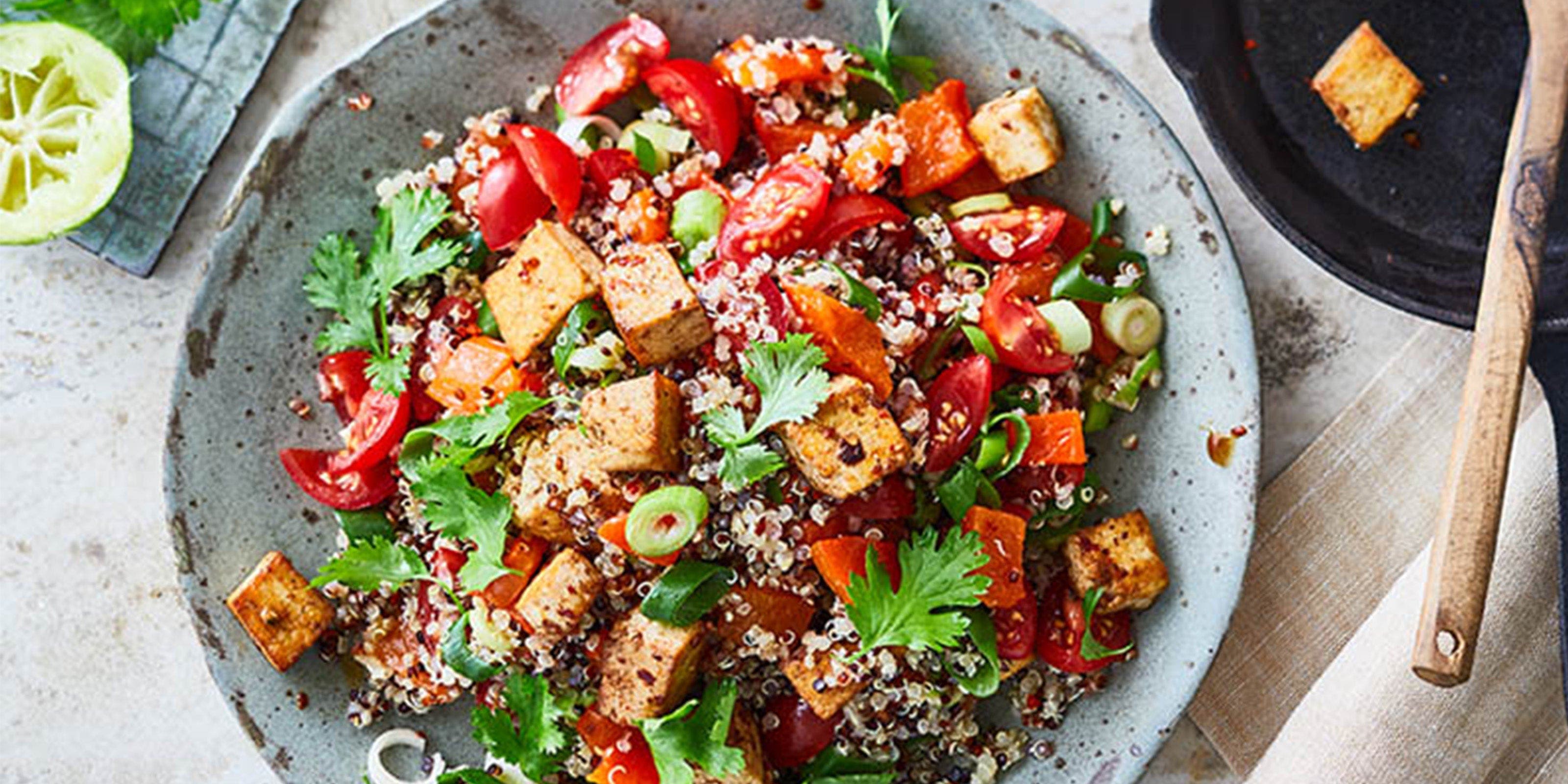 Ein Teller Quinoa-Salat mit marinierten Tofu-Würfeln