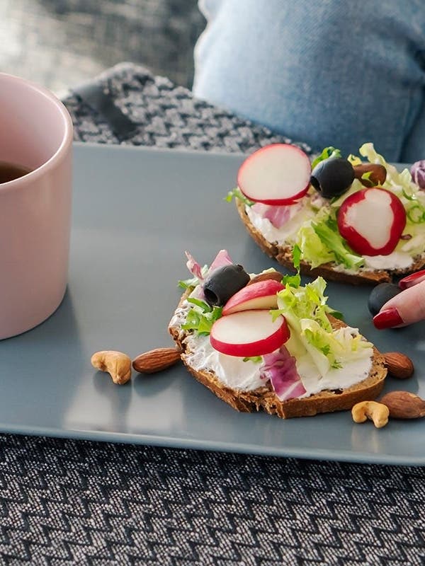 Ein Frühstücksteller mit belegtem Brot und Kaffee, daneben liegt das Blutzuckermessgerät.