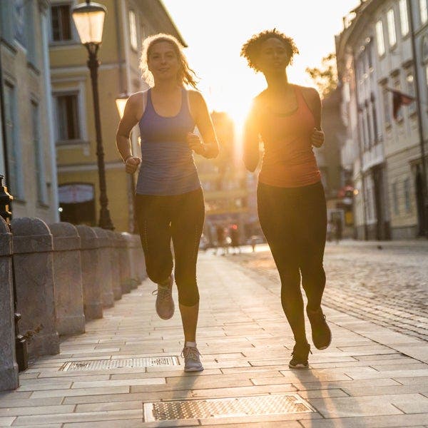 Zwei junge Frauen joggen auf einer Straße