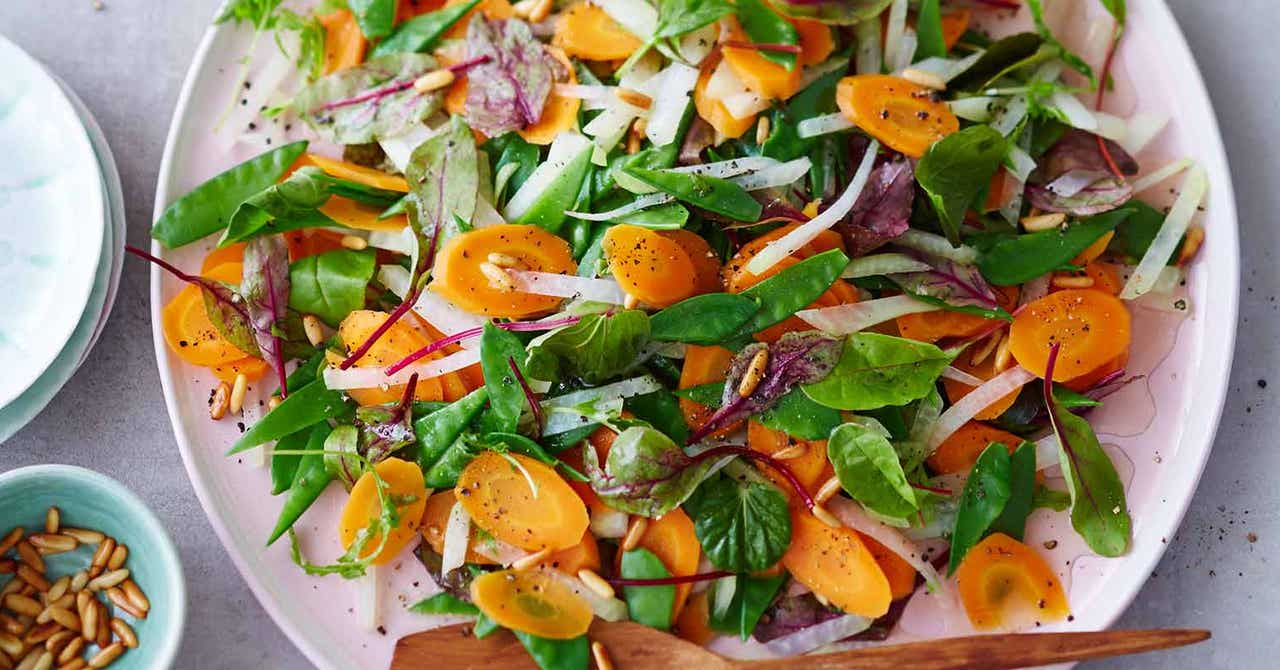 Ein Teller mit einem frischen Möhren-Kohlrabi-Salat mit Pinienkernen