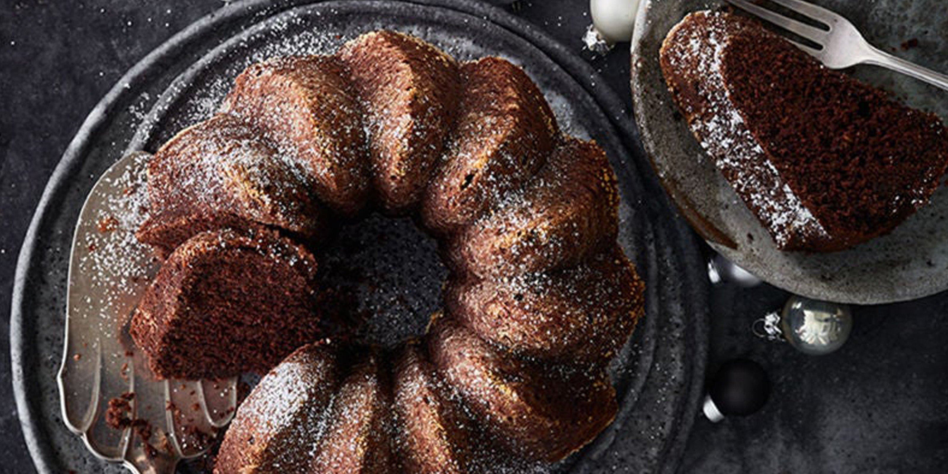 Gewürzkuchen-Gugelhupf auf Servierplatte und Weihnachtskugeln daneben