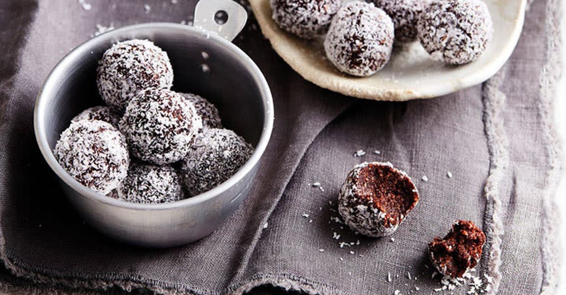 Energyballs mit Kokosraspeln, in zwei Schalen angerichtet.