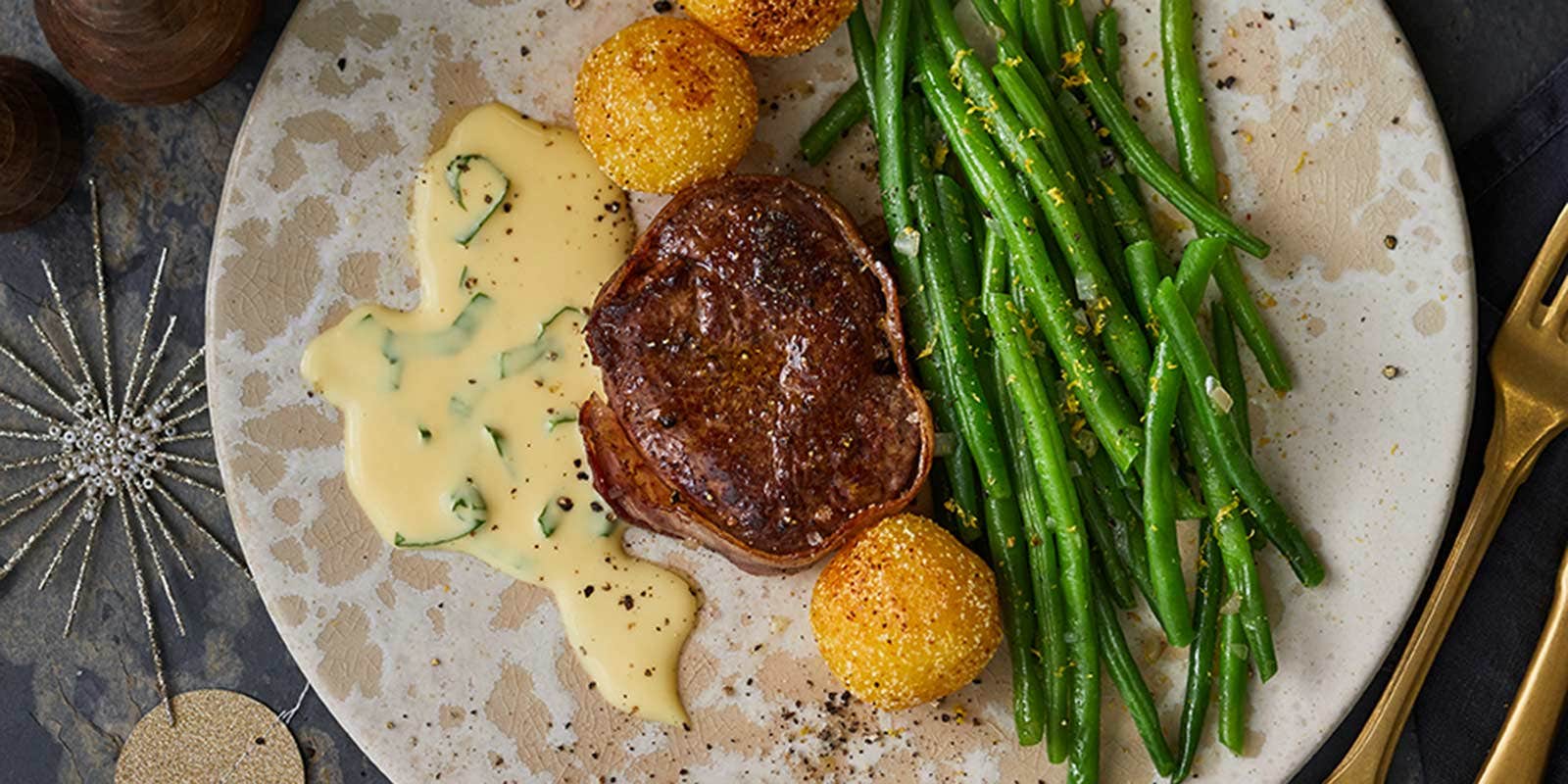 Ein Stück Rinderfilet mit Bohnen und Knödeln ist weihnachtlich angerichtet. 