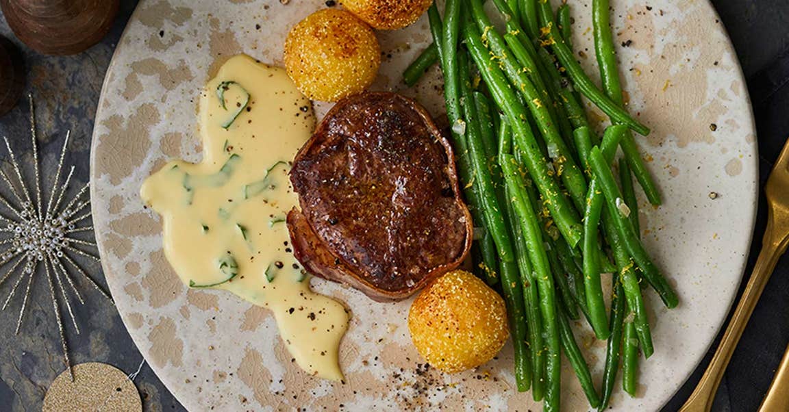 Ein Stück Rinderfilet mit Bohnen und Knödeln ist weihnachtlich angerichtet.
