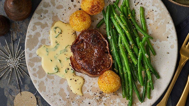 Ein Stück Rinderfilet mit Bohnen und Knödeln ist weihnachtlich angerichtet. 