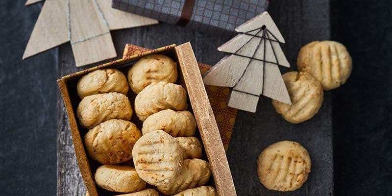 Helle Cookies in einer Schachtel auf dunklem Hintergrund