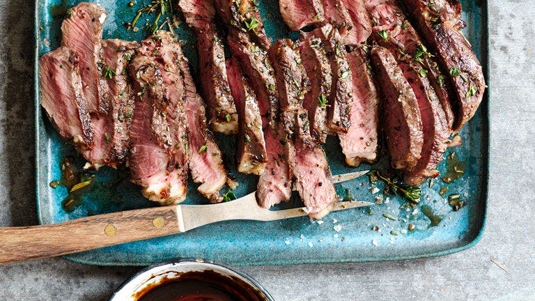 Ein Stück gebratenes Rindfleisch in Scheiben, das auf einem Teller angerichtet wurde