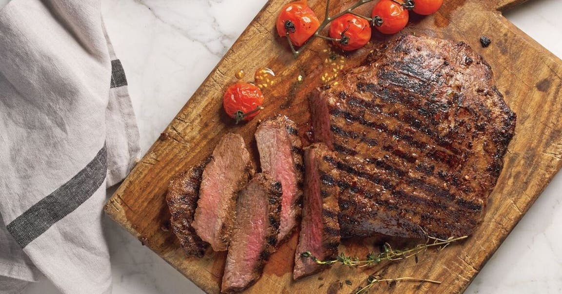 Ein Stück gebratenes rotes Fleisch auf einem Schneidebrett