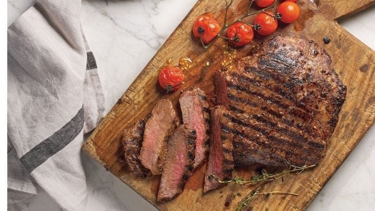 Ein Stück gebratenes rotes Fleisch auf einem Schneidebrett