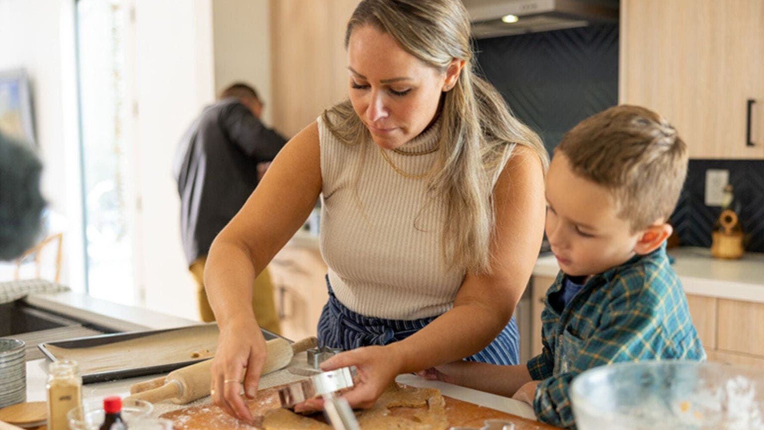 Blonde Frau backt Plätzchen mit kleinem Sohn