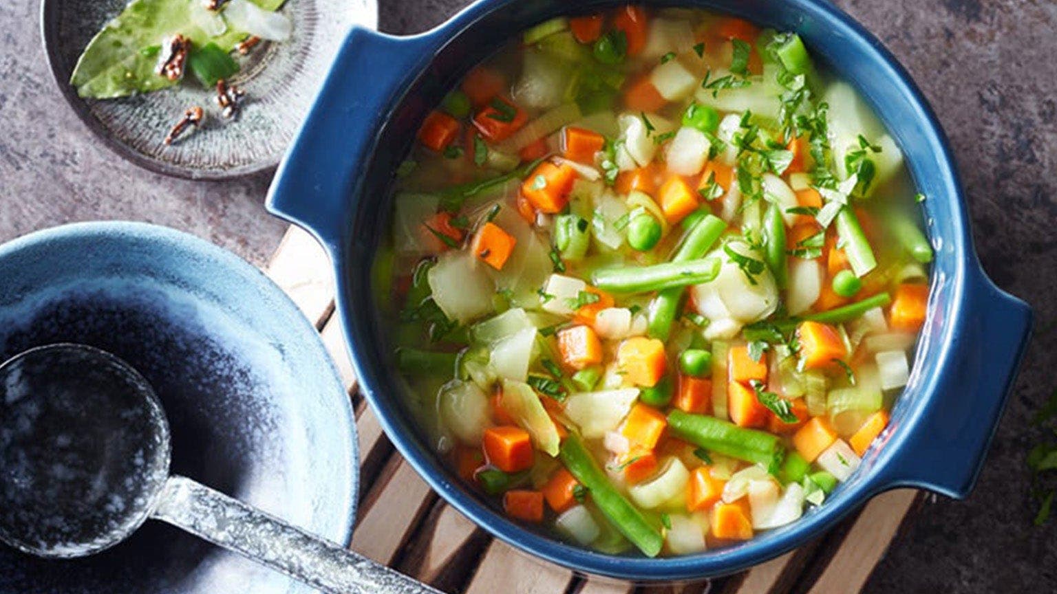 0-Punkte-Gemüsesuppe mit Möhren, Lauch und Kartoffel in blauem Topf