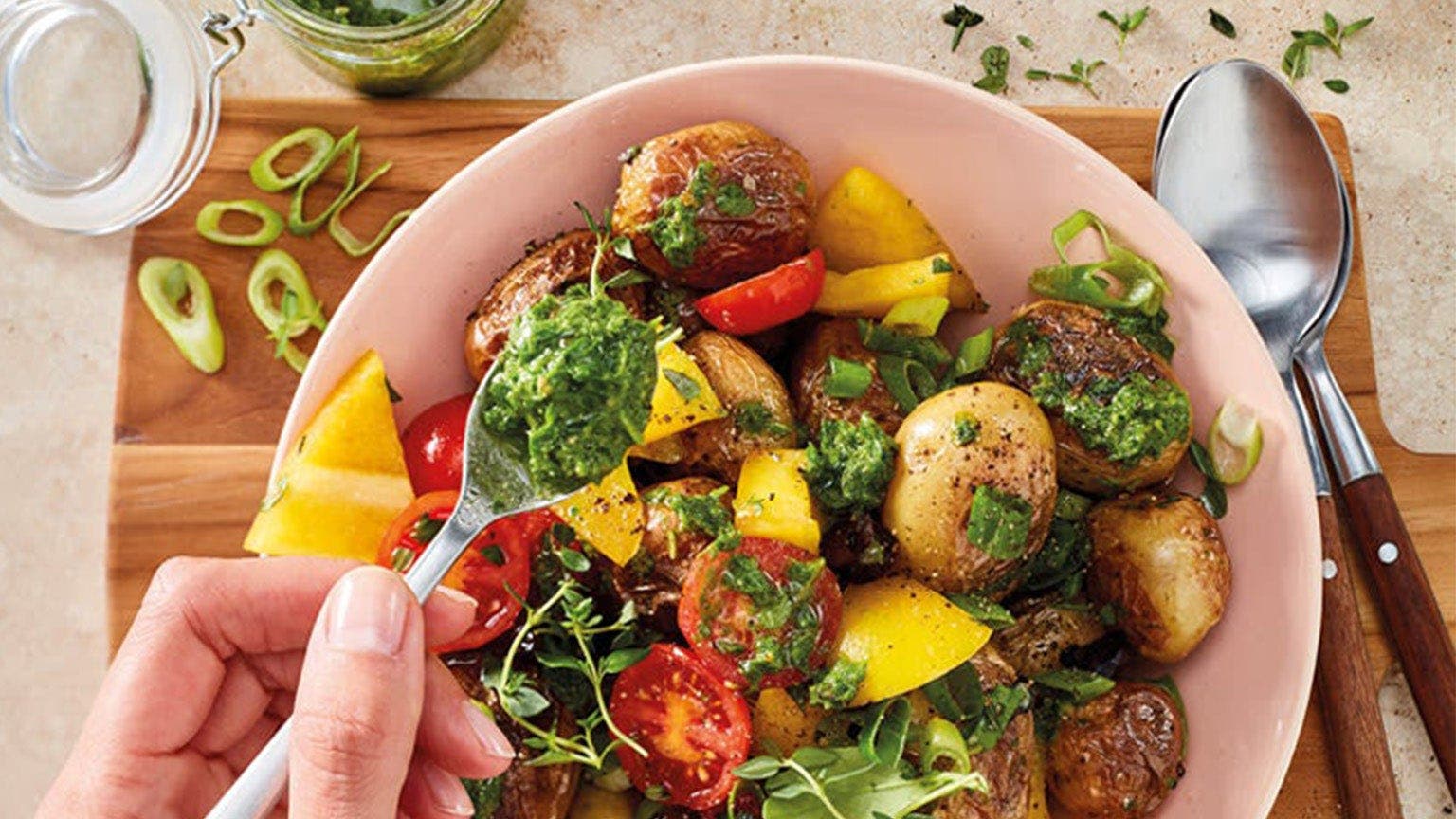 Salat mit Falafeln, Paprika und Tomate mit Pesto in einer Schale