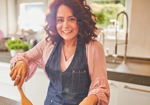 WW Mitglied Simone kocht und lacht in die Kamera