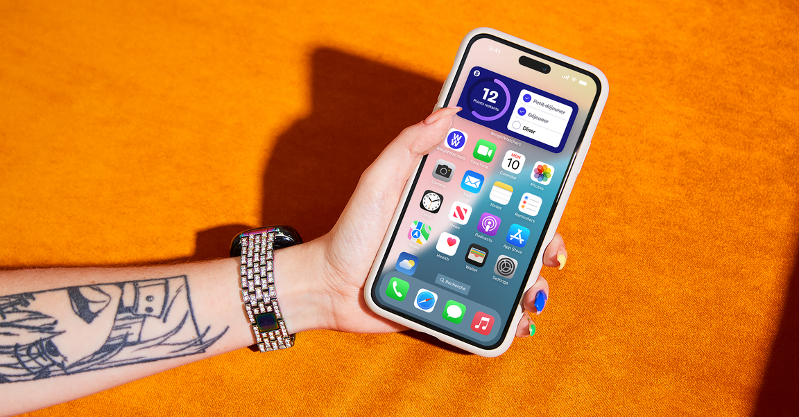 Une personne tient un iPhone, présentant un mélange de technologie et d’expression personnelle.