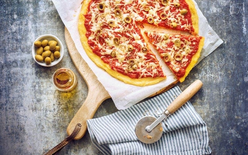 A pizza on a sheet of parchment paper.