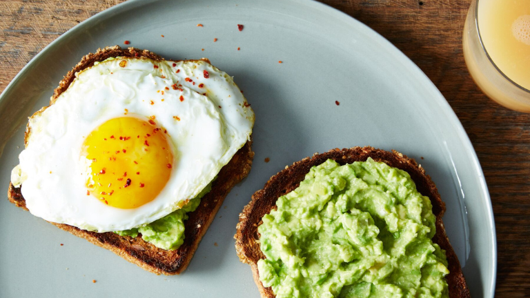 Toast met avocadospread en een spiegelei met hele dooier