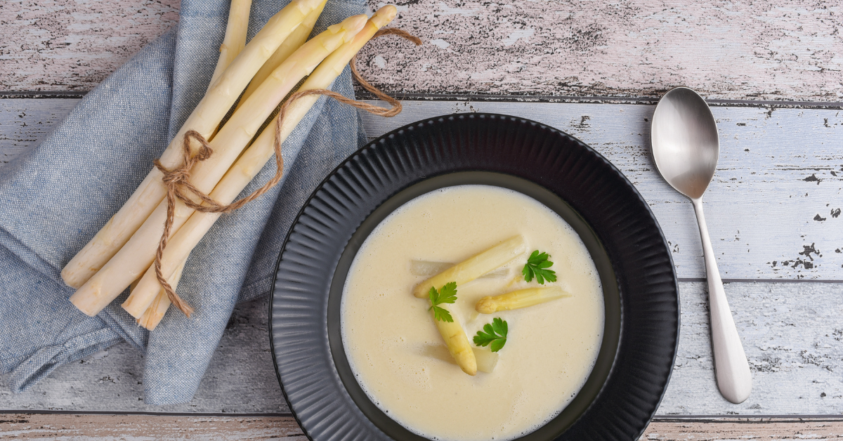 Bundeltje witte asperges en een soepbord met aspergesoep