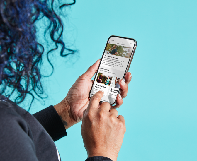 A woman looks at the WW app on her SmartPhone.