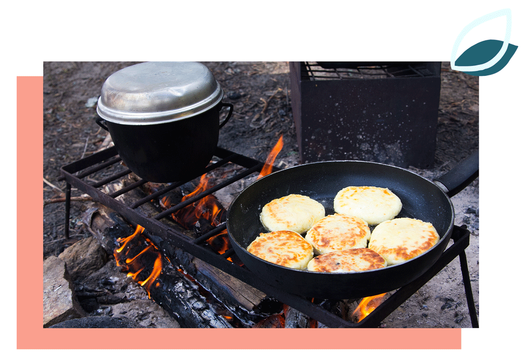 stekpanna med plättar i på ett galler över öppen eld