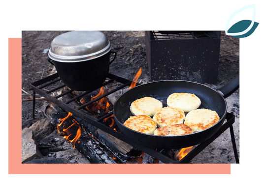 stekpanna med plättar i på ett galler över öppen eld