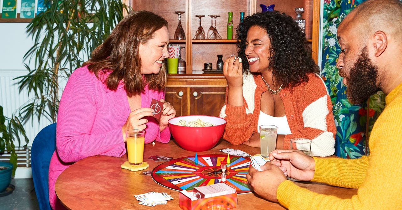 a group of people sitting around a table playing cards