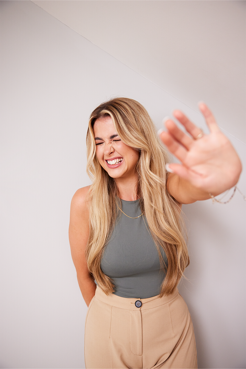 Image of Chloe smiling with her hand out in front of her
