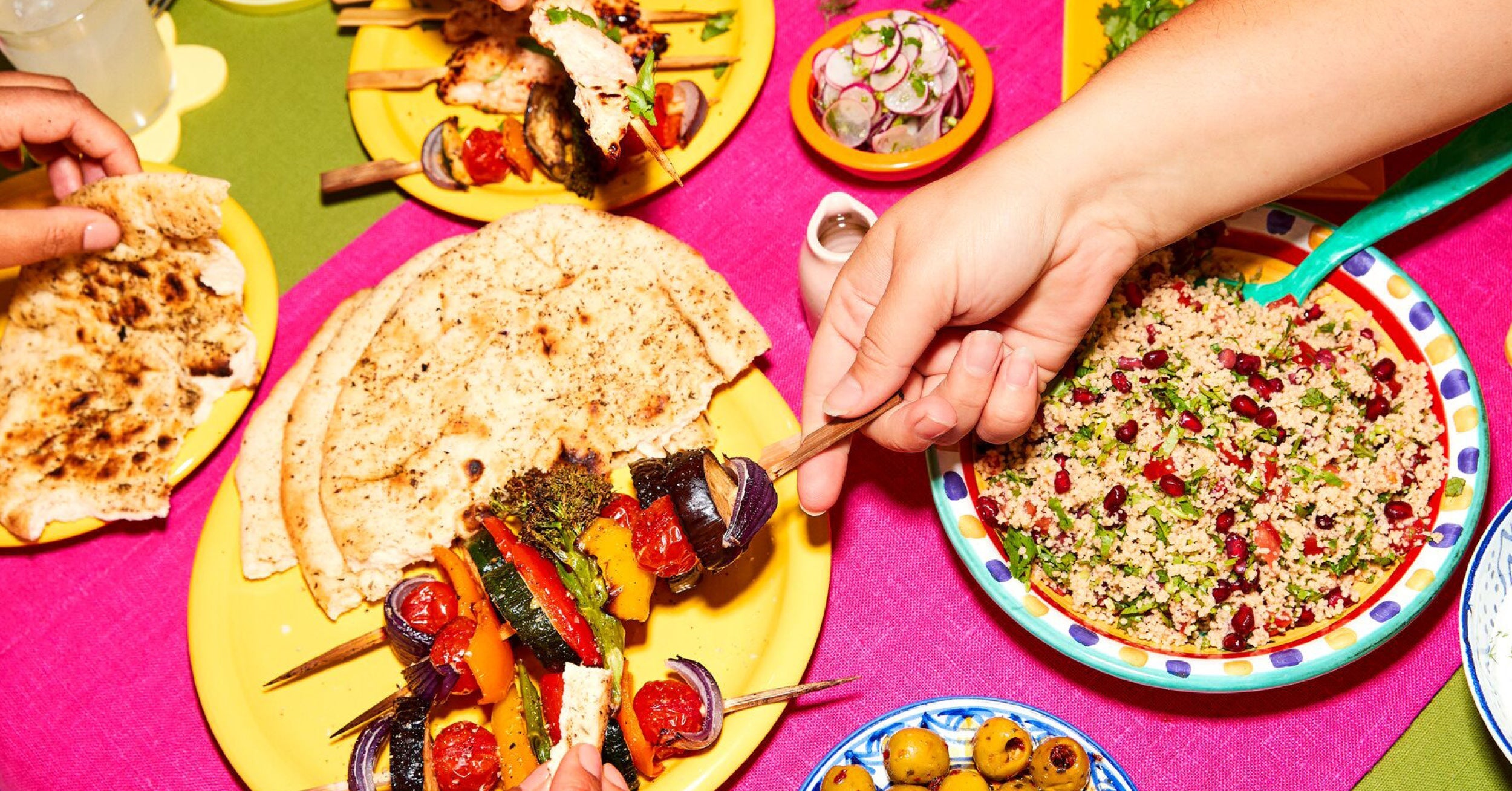 a person holding a skewer of vegetables