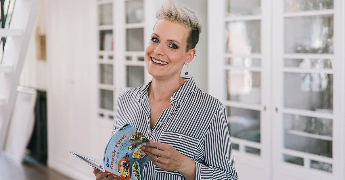 a woman smiling and holding a book