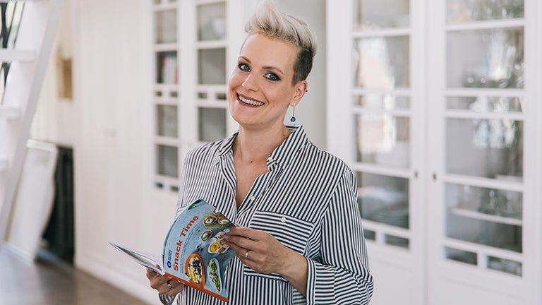 a woman smiling and holding a book