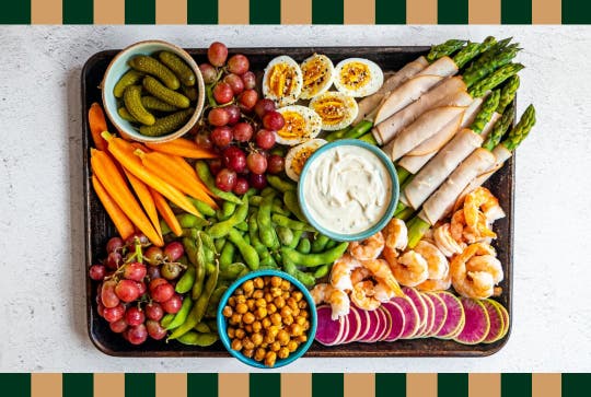 Dinner charcuterie board with edamame, shrimp, grapes, boiled eggs and more