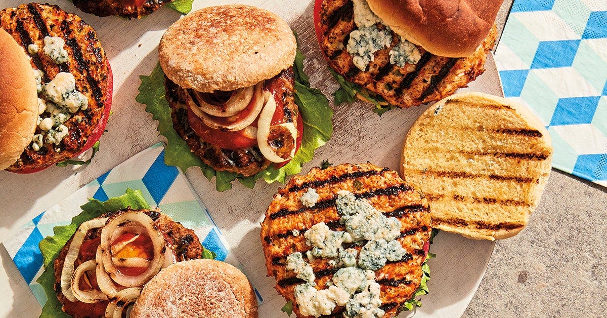 4 burger patties cooking on an outdoor grill
